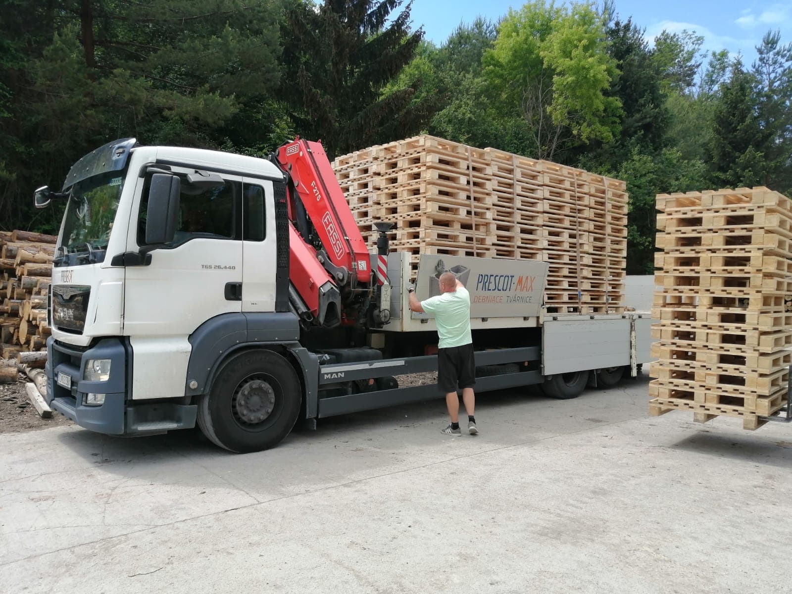 Pallets being loaded onto an MMLES lorry with a lorry-mounted crane